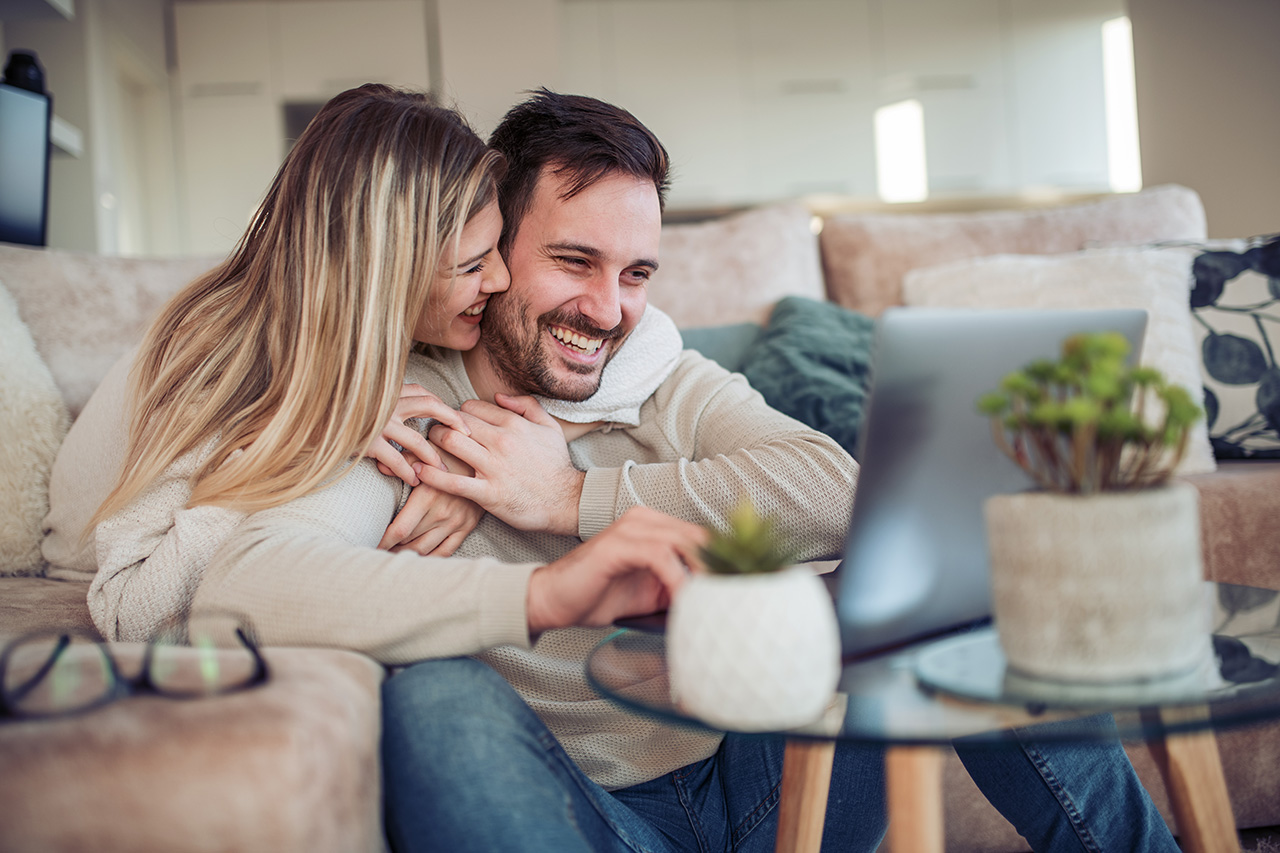 cheerful young couple using laptop